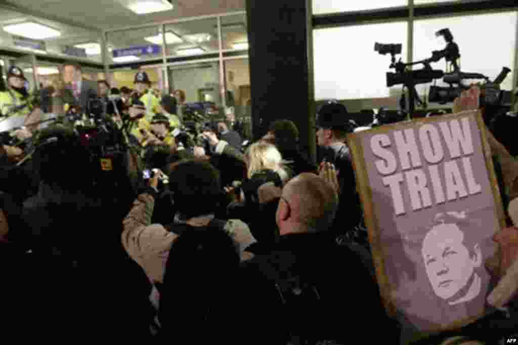 A supporter, right, of Wikileaks founder Julian Assange holds up a placard as Mark Stephens, lawyer of Julian Assange talks to the media outside the City of Westminster Magistrates Court in London where Julian Assange is in court for his bail hearing, Tu