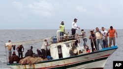 African migrants sit aboard a boat after being rescued after fleeing Libya by Tunisian coastguard and sailors off the Tunisian coast, June 5, 2011