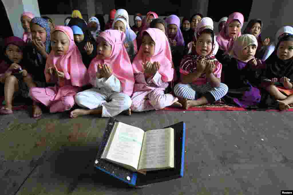 Anak-anak berdoa sebelum mengaji di dalam Masjid Al-Satie, di Baseco, kota Tondo, Metro Manila (29/6). (Reuters/Romeo Ranoco)