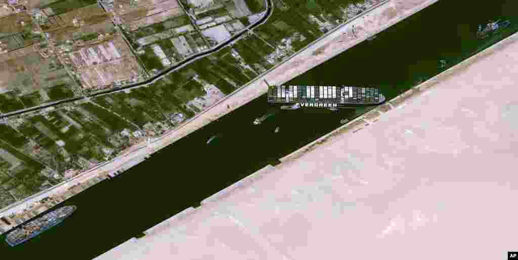 This satellite image shows the cargo ship MV Ever Given stuck in the Suez Canal near Suez, Egypt. The skyscraper-sized cargo ship got wedged across the Suez Canal and has been impeding global shipping.