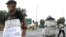 Un homme fait la manche (g) tandis qu'un autre collecte des matériaux recyclables, à une intersection de rue à Johannesburg, en Afrique du Sud, le 16 mars 2016.