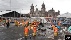 Para petugas kebersihan membersihkan lapangan Zocalo di Mexico City, pasca dibubarkannya aksi mogok ribuan guru oleh polisi huru-hara ibukota Meksiko tersebut, Jumat (13/9).