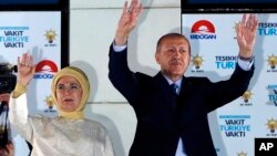 Turkey's President Recep Tayyip Erdogan (R) accompanied by his wife Emine waves to supporters of his ruling Justice and Development Party (AKP) in Ankara, Turkey, June 25, 2018. 