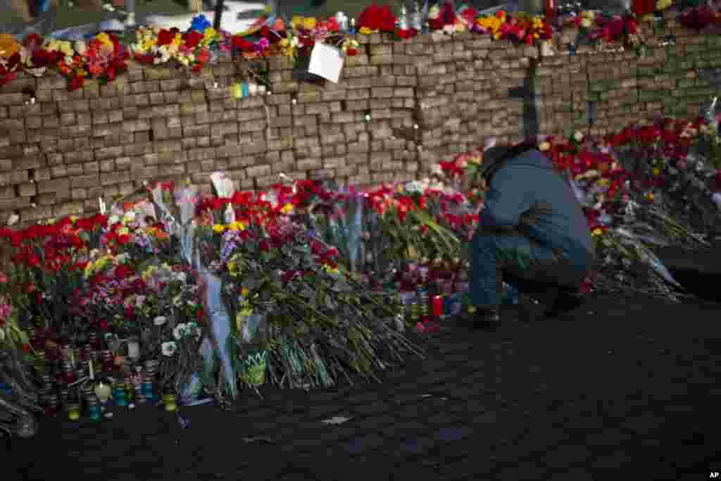Hàng dài các bó hoa đặt trước một chướng ngại vật tại Quảng trường Độc lập ở Kiev, ngày 24/2/2014. Ukraina đã ra trát bắt giữ Tổng Thống bị lật đổ Viktor Yanukovych, tố cáo ông và các giới chức khác về tội giết hại hàng loạt người biểu tình.