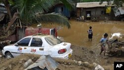 Residents stand in floodwaters after flash floods brought by Typhoon Washi struck Iligan city in the southern Philippines, December 17, 2011.