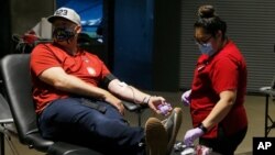 Former Arizona Diamondbacks MLB baseball player J.J. Putz, left, donates blood during a Red Cross and Diamondbacks blood drive at Chase Field Tuesday, April 28, 2020, in Phoenix. According to the Red Cross, as of April 5, nearly 14,000 Red Cross…