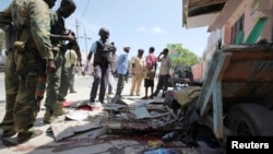 Somali soldiers stand at the scene of an explosion in the capital Mogadishu, May 3, 2014.