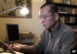 In this image taken from Jan 6, 2008, video footage by AP Video, Liu Xiaobo looks at documents in his home in Beijing, China.