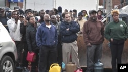 Một đám đông tập trung chờ tại một trạm xăng ở Brooklyn, New York, mang theo những can chứa để mua xăng.