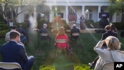Reporters are seated a social distance apart as President Donald Trump speaks about the coronavirus in the Rose Garden of the White House, April 15, 2020, in Washington.