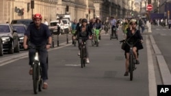 People ride on Rivoli street in Paris, Wednesday, Sept. 13, 2023. (AP Photo/John Leicester)