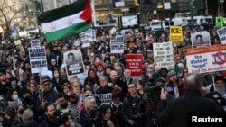 Demonstran memegang plakat selama protes menyusul penangkapan oleh agen imigrasi AS terhadap aktivis mahasiswa pro-Palestina Mahmoud Khalil di Universitas Columbia, di Foley Square di New York City, 10 Maret 2025.