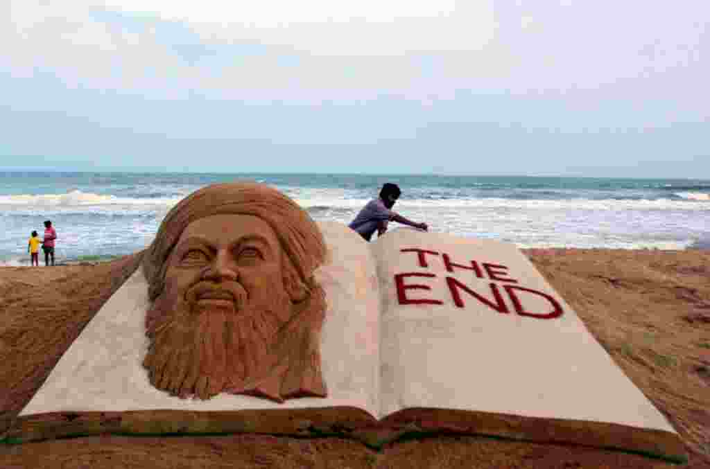 May 2: Sand artist Sudarshan Pattnaik gives finishing touches to a sculpture to mark the killing of Osama bin Laden at the golden sea beach at Puri, Orissa, India. (AP Photo/Biswaranjan Rout)