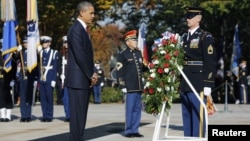 President Barack Obama (L) is seen after placing a Veterans Day wreath at the Tomb of the Unknowns at Arlington National Cemetery in Arlington, Virginia, November 11, 2012. 