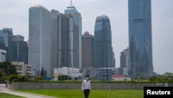 一名戴著口罩的男子行走在空空蕩蕩的香港金融區。 （2020年3月27日）