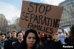 美国搜捕非法移民的行动在各地引起了示威抗议，有人举着标语“停止让家庭分离”