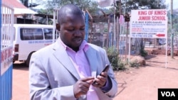 Gerald Businge demonstrates the Action for Transparency app, Kampala, July 2, 2014. (Hilary Heuler/VOA)