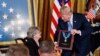 Presiden Donald Trump menganugerahkan penghargaan Medal of Honor kepada Letnan Satu Anumerta AD Garlin Conner kepada janda mendiang, Pauline Conner, secara anumerta dalam sebuah acara di East Room Gedung Putih, Selasa, 26 Juni 2018 (foto: AP Photo/Pablo Martinez Monsivais)