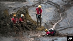 Rescue workers take a rest from their search for victims at the town of Bento Rodrigues, after a dam burst on Thursday, in Minas Gerais state, Brazil, Nov. 8, 2015.