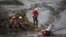 FILE - Rescue workers take a rest from their search for victims at the town of Bento Rodrigues, after a dam burst in Minas Gerais state, Brazil, Nov. 8, 2015.
