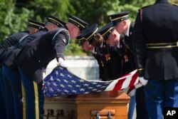 FILE - In this Sept. 6, 2018 photo, the 3rd Infantry Regiment stretches the American flag over the casket containing the remains of one of two unknown Civil War Union soldiers at Arlington National Cemetery in Arlington, Va.