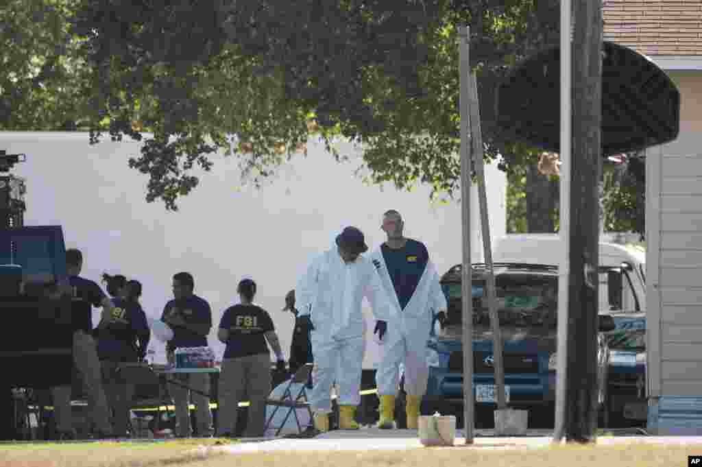 Members of the FBI walk behind the First Baptist Church of Sutherland Springs after a fatal shooting, Nov. 5, 2017, in Sutherland Springs, Texas.