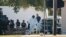 Members of the FBI walk behind the First Baptist Church of Sutherland Springs after a fatal shooting, Nov. 5, 2017, in Sutherland Springs, Texas.