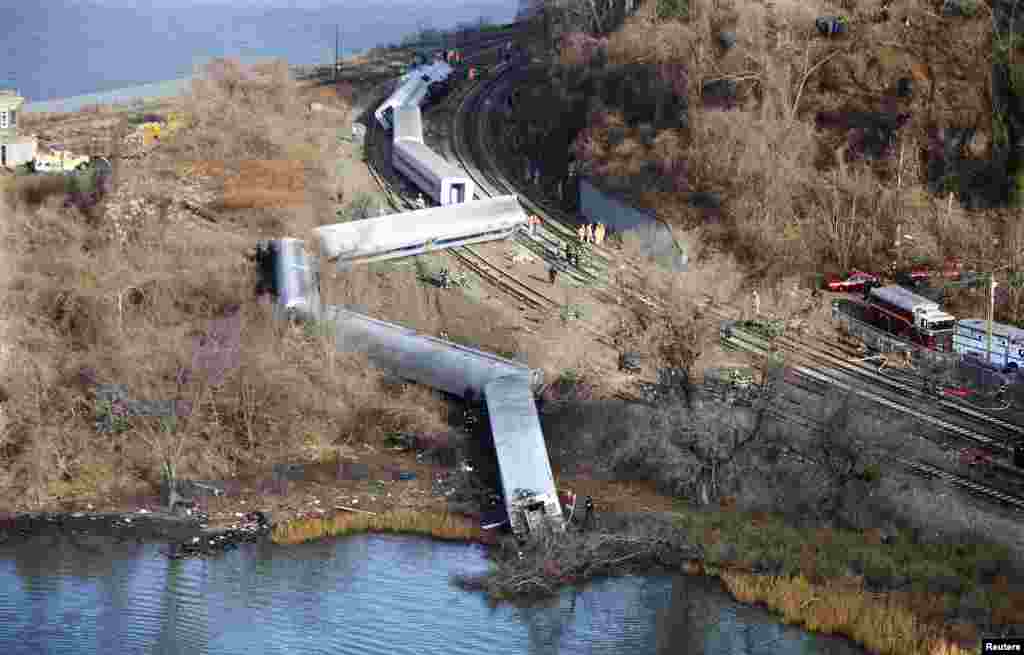 Emergency workers examine the site of a Metro-North train derailment in the Bronx borough of New York, Dec. 1, 2013. 