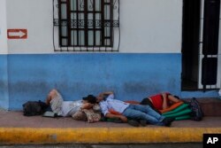 Migrants sleep on a sidewalk in Tapachula, Chiapas state, Mexico, June 8, 2019. President Donald Trump has put on hold his plan to begin imposing tariffs on Mexico, saying the U.S. ally will take "strong measures" to reduce the flow of Central American migrants toward the U.S.border.