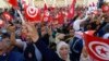 Des Tunisiens brandissent le drapeau national lors d'une manifestation contre le président Saied le long de l'avenue Habib Bourguiba dans la capitale Tunis, le 10 octobre 2021. 