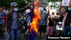 FILE - Protesters against Myanmar's junta burn the flag of the Association of Southeast Asian Nations (ASEAN), in Mandalay.