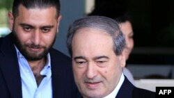 FILE - Syrian Deputy Foreign Minister Faisal Mekdad (R) leaves the hotel, where the team of chemical experts from the Organization for the Prohibition of Chemical Weapons (OPCW) are residing, on April 15, 2018, in Damascus.