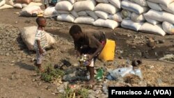 Meninos apanham garrafas de plástico vazias na estação de Caminhos de Ferro de Moçambique em Moatize