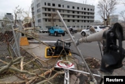 A broken traffic light, a street sign and branches lie on the street after the area was hit by Hurricane Maria, in San Juan, Puerto Rico, Sept. 22, 2017.