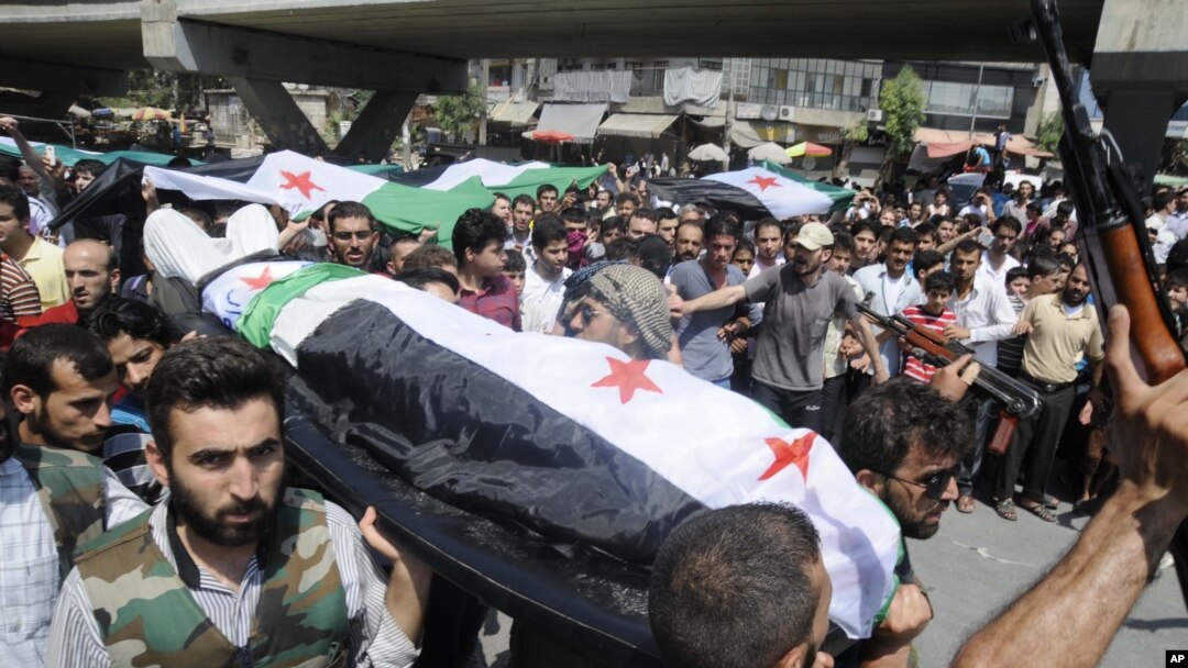 People carry a body of a person killed in clashes in Aleppo, Syria, Friday, July 27, 2012.