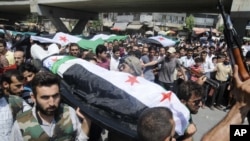 People carry a body of a person killed in clashes in Aleppo, Syria, Friday, July 27, 2012.