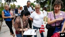 FILE - Florida residents stand in line to register to vote in November elections, in Miami, Oct. 11, 2016.
