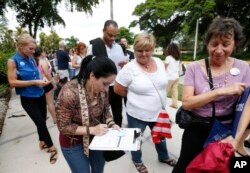 FILE - Campaign Florida residents stand in line to register to vote in November elections, in Miami, Oct. 11, 2016.