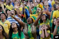 Aficionados al fútbol brasileños aplauden mientras miran una transmisión en vivo del partido de la Copa Mundial de su equipo contra Serbia, en Praca Maua, en Río de Janeiro, Brasil, el miércoles 27 de junio de 2018. (AP Photo / Silvia Izquierdo)