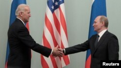 FILE - Russia's then-Prime Minister Vladimir Putin shakes hands with then-U.S. Vice President Joe Biden during their meeting in Moscow, March 10, 2011.