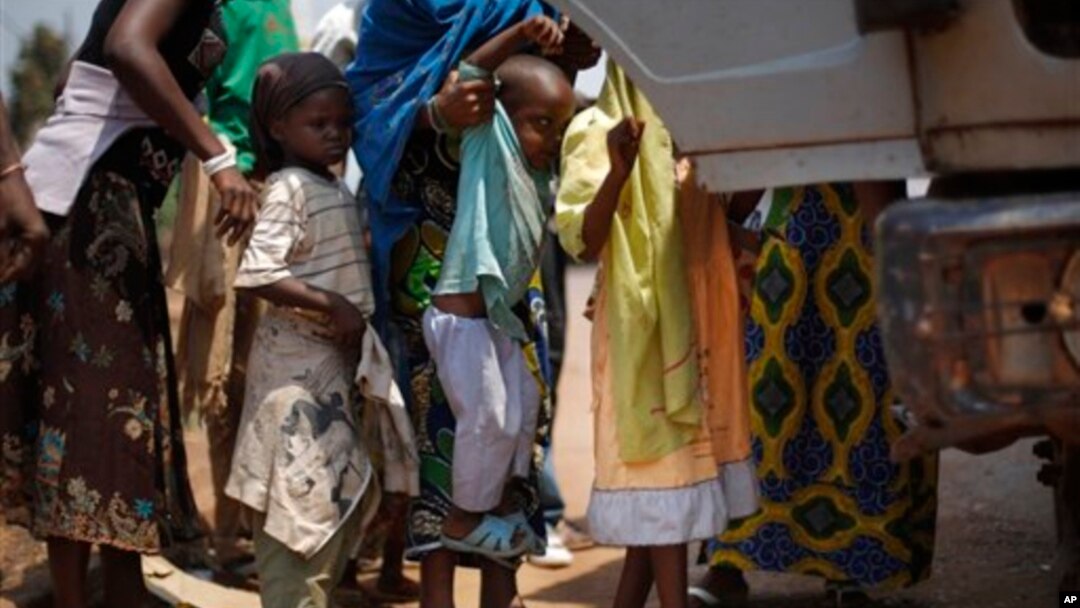 Muslim Children are lifted into a truck that had fallen into a ditch while turning around in Bangui, Central African Republic, Friday, Feb. 14, 2014. 