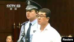 Chongqing municipality ex-police chief Wang Lijun (R) reads a statement during his sentencing inside the courtroom of the Chengdu People's Intermediate Court in Chengdu, Sichuan province in this still image taken from video, Sept. 24, 2012. 
