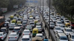 In this Jan. 16, 2016, file photo, vehicles move slowly through a traffic intersection after the end of a two-week experiment to reduce the number of cars to fight pollution in in New Delhi, India. (AP Photo/Altaf Qadri, File)