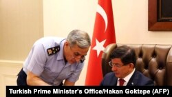 Komandan AU Turki Jenderal Akin Ozturk, kiri, berbicara dengan Perdana Menteri Turki Ahmet Davutoglu dalam pertemuan keamanan khusus tentang ISIS di Suriah dan PKK di Irak, di Istana Cankaya, Ankara, 25 Juli 2015. 