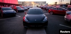 FILE - Tesla Model 3 cars are seen at an event at the factory handing over its first 30 Model 3 vehicles to employee buyers at the company’s Fremont facility in California, July 28, 2017.