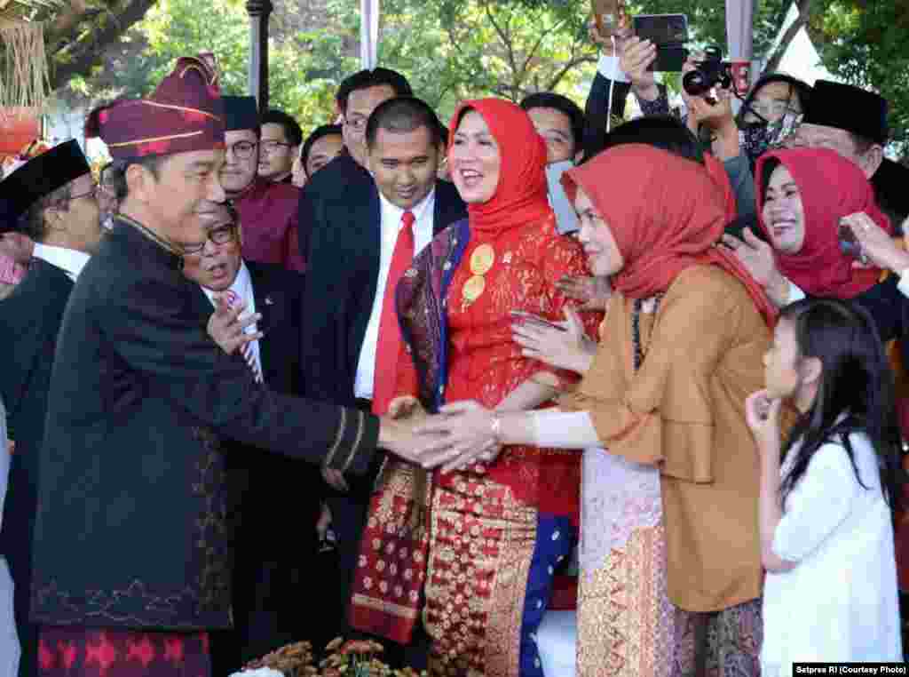 Presiden Joko Widodo menyalami hadirin yang ikut secara langsung menyaksikan pengibaran bendera di Istana Merdeka Jakarta. Sebagian di antara mereka tidak segan-segan meminta swafoto (selfie) dengan presiden, Jakarta, 17 Agustus 2017. (Courtesy: Setpres RI)