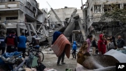 FILE—Palestinians inspect the damage of residential buildings after an Israeli airstrike in Rafah, southern Gaza Strip, March 24, 2024.