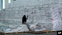 FILE: A worker walks next to food earmarked for the Tigray and Afar regions in a World Food Programme (WFP) warehouse in Semera, Ethiopia, Feb. 21, 2022. The WFP has suspended aid deliveries to Ethiopia’s northern Tigray region amid an internal theft investigation. 