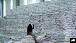 FILE - A worker walks next to a pile of sacks of food earmarked for the Tigray and Afar regions in a warehouse of the World Food Programme (WFP) in Semera, the regional capital for the Afar region, in Semera, Ethiopia, Feb. 21, 2022. 