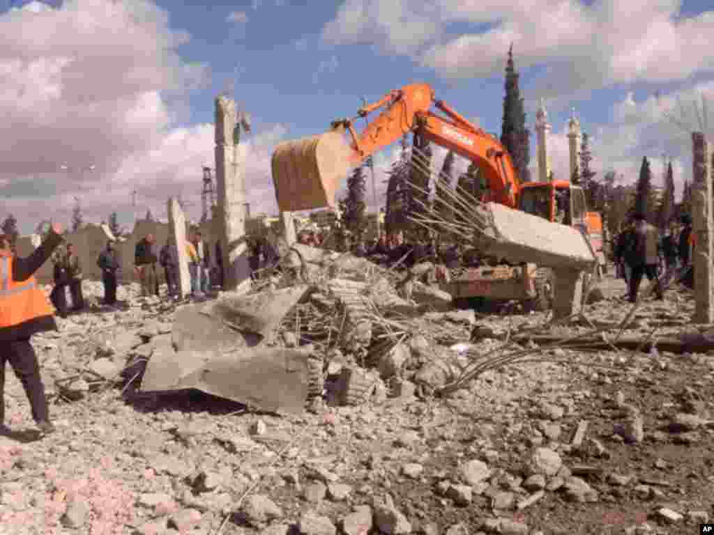 An excavator removes debris at the site of an explosion in Syria's northern city of Aleppo, February 10, 2012. (Reuters)